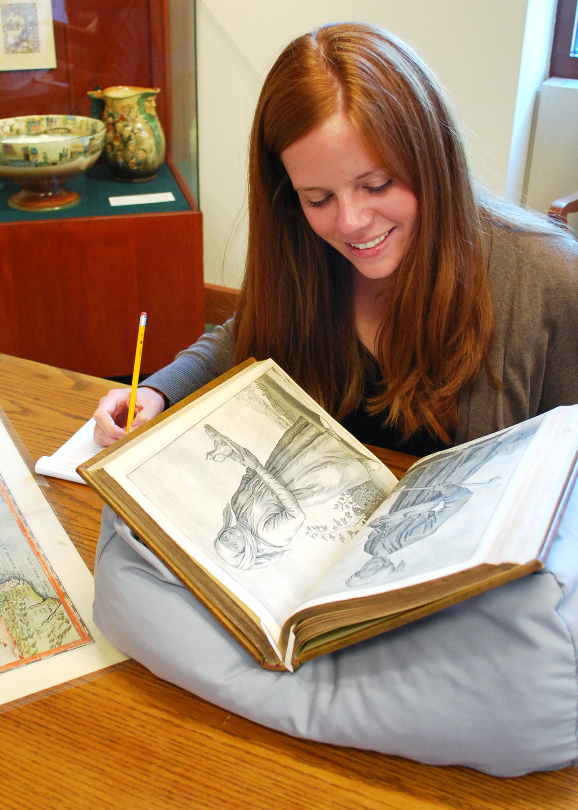 Student looking through a special collections book.