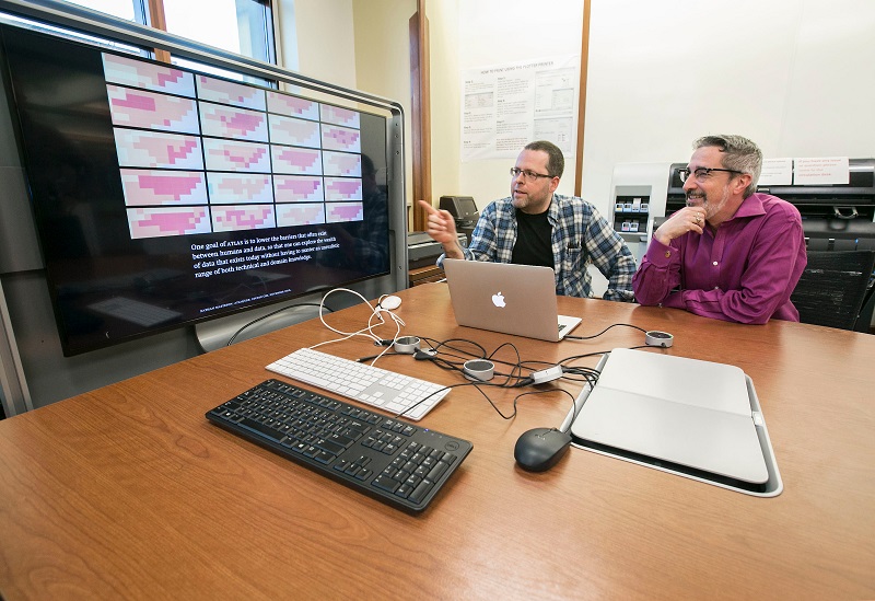 Photo of two professors viewing a presentation in the Scholar's Lab.